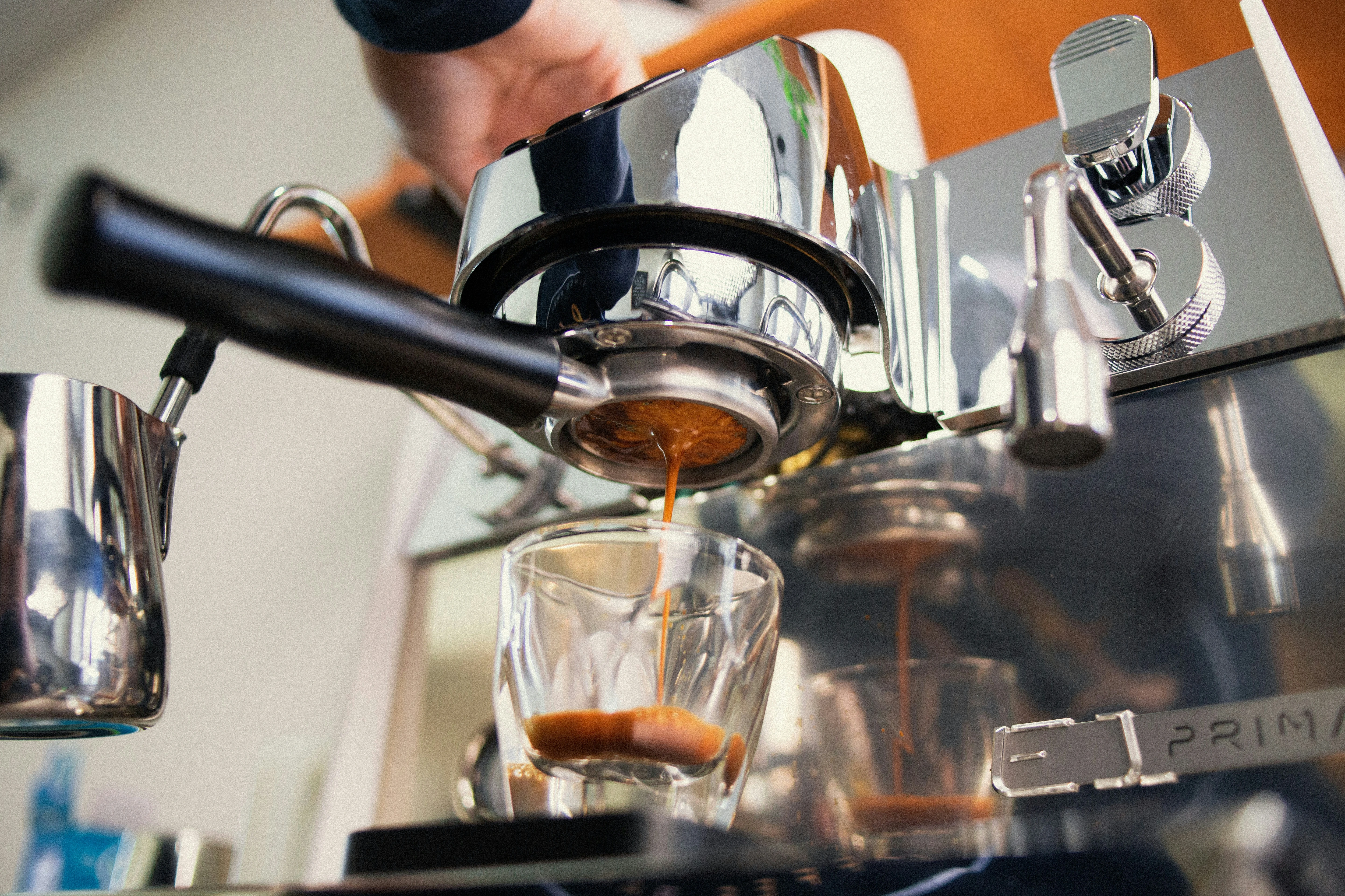 Verse espresso die vanuit een koffiemachine in een glazen kop loopt